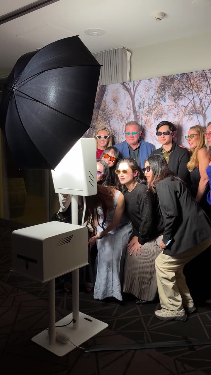 Large group of colleagues posing in a photo booth at a Bellroy conference event