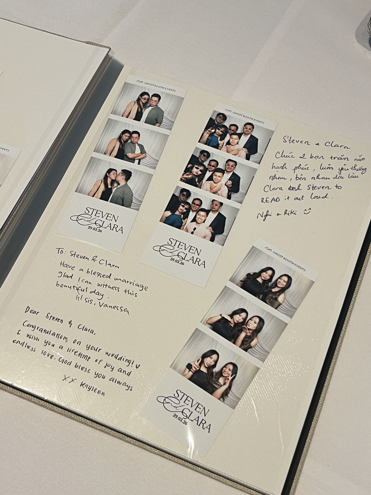 Open linen guestbook page with three Ghost Booth Events photo strips printed with Steven and Clara 29.03.26, surrounded by handwritten messages in English and Vietnamese